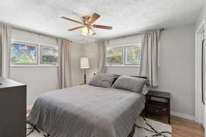 Bedroom featuring wood finished floors, a textured ceiling, and ceiling fan