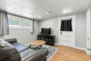 Living area with light wood-style flooring and recessed lighting