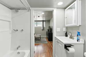 Full bathroom with vanity, shower / washtub combination, and wood finished floors