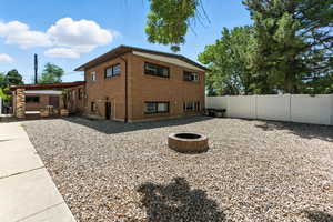 View of side of home featuring an outdoor fire pit and brick siding