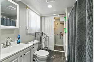 Bathroom with a textured ceiling and vanity