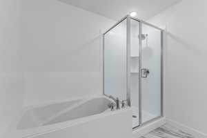 Bathroom featuring a stall shower, a bath, and marble finish floors
