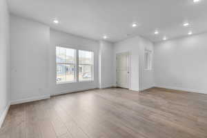 Empty room with light wood-type flooring and recessed lighting