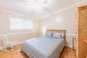 Bedroom featuring crown molding, wood finished floors, and ceiling fan