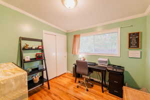 Office area with ornamental molding and wood finished floors