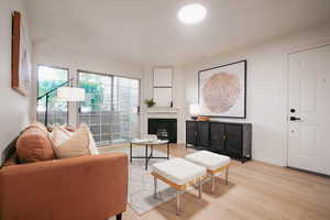 Living area featuring light wood-style flooring and a fireplace