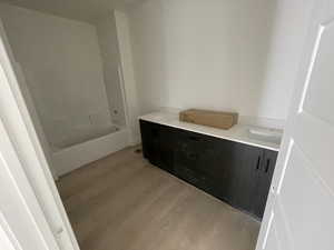 Full bathroom with double vanity and wood finished floors