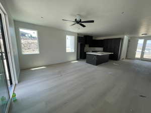 Unfurnished living room featuring light wood finished floors and a ceiling fan