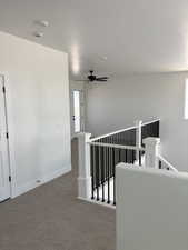 Hallway with an upstairs landing and carpet flooring
