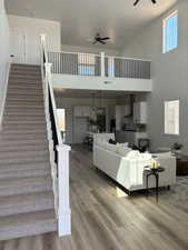 Living room with a large ceiling fan, LVP finished floors, View of upstairs Loft