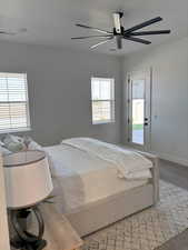 1st Floor Primary Bedroom featuring, Exterior door to patio, ceiling fan