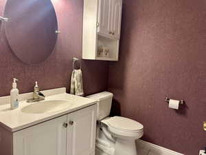 Half bathroom with vanity and tile patterned floors