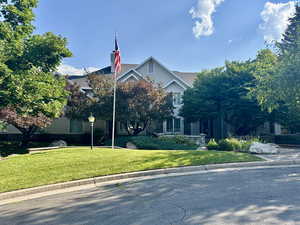 Front view of property featuring mature trees and beautiful entry
