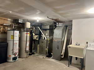 Basement with washer / dryer, water heater, and heating unit
