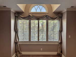 Detailed view of picture window in primary bedroom with crown molding