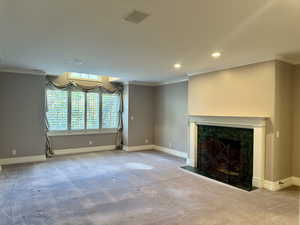 Luxurious primary bedroom featuring ornamental molding, carpet floors, a fireplace, and recessed lighting