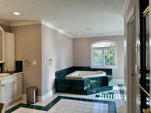 Primary bathroom featuring tile patterned flooring, a tub with jets, vanity, recessed lighting,  deck access and ornamental molding