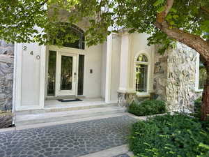 View of exterior entry with stone siding and stucco siding