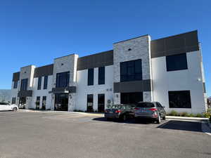 View of building exterior with uncovered parking - back of bldg