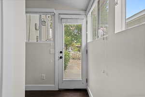 Doorway featuring dark wood-type flooring and lofted ceiling