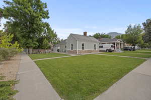 View of front facade with a chimney, stone siding, stucco siding, and a mountain view