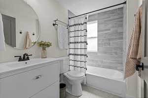 Full bathroom with vanity, shower / bath combo with shower curtain, and tile patterned flooring