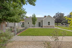 Single story home with stucco siding, a chimney, and stone siding