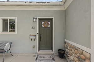 View of exterior entry with stucco siding