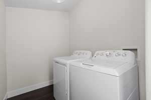 Laundry room featuring separate washer and dryer and dark wood-style floors