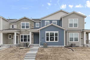 View of front of property with stone siding, a standing seam roof, a metal roof, and board and batten siding