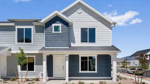 View of front of house featuring a shingled roof and a porch
