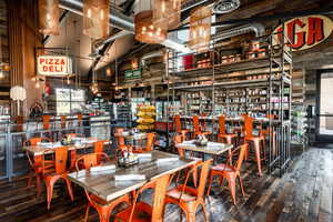 Dining space with a high ceiling, wooden walls, and hardwood / wood-style flooring