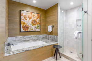 Bathroom featuring a shower stall, a bath, and recessed lighting