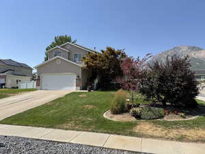 View of front of home with concrete driveway, stucco siding, and a mountain view