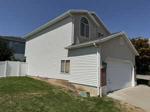 View of property exterior featuring driveway and an attached garage