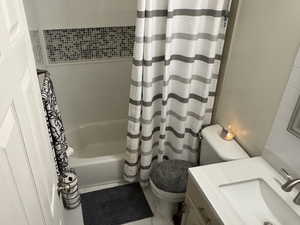 Full bathroom with shower / tub combo with curtain and vanity