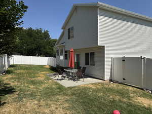 Back of house with a fenced backyard and a patio area