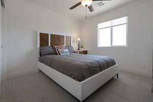 Carpeted bedroom featuring baseboards and a ceiling fan