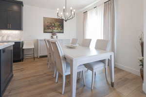 Dining room with light wood-type flooring and a chandelier