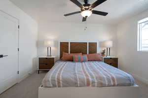 Carpeted bedroom featuring baseboards and a ceiling fan