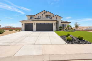 Modern inspired farmhouse featuring a front lawn, a tile roof, stucco siding, concrete driveway, and an attached garage