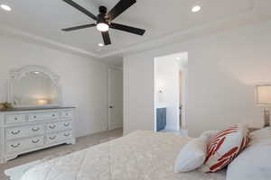 Bedroom featuring recessed lighting, a tray ceiling, connected bathroom, ceiling fan, and light colored carpet