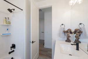 Bathroom featuring shower / bath combination, wood finished floors, and vanity