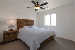 Carpeted bedroom featuring baseboards and ceiling fan