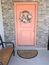 Property entrance featuring brick siding