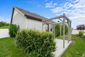 View of side of property with a shingled roof and a patio area