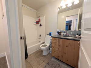 Full bath featuring shower / bath combination with curtain, tile patterned floors, and vanity