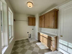 Laundry area featuring cabinet space, washer hookup, light floors, and electric dryer hookup