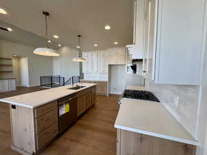 Kitchen featuring backsplash, dark wood-type flooring, recessed lighting, stainless steel appliances, and hanging light fixtures