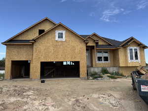 Property in mid-construction with stucco siding, a garage, and a shingled roof